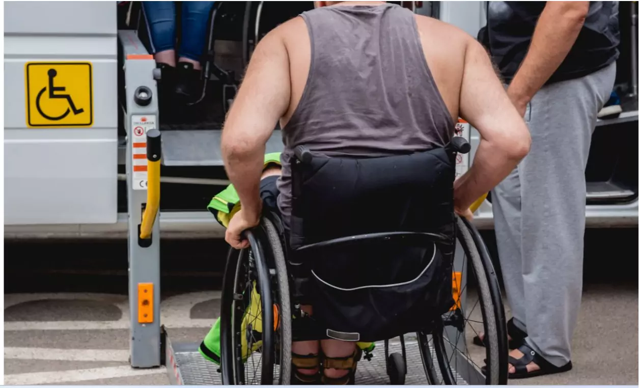 Un hombre con discapacidad en silla de ruedas se dispone a subir a un taxi